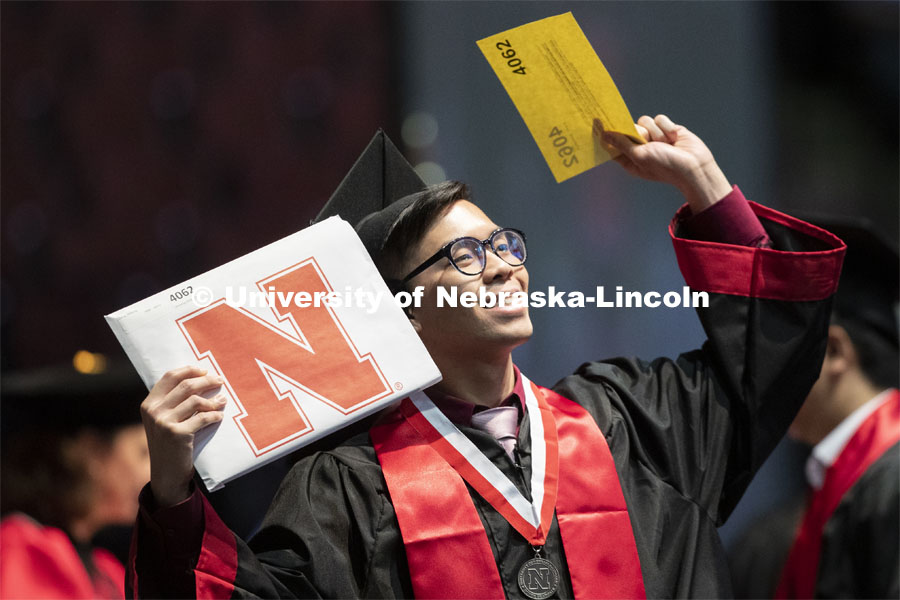 Jinhoong Cheng gestures to family and friends after receiving his College of Business diploma. Undergraduate commencement at Pinnacle Bank Arena, May 4, 2019. Photo by Craig Chandler / University Communication.