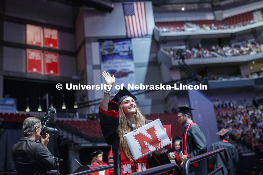 Marit Koszewski waves to family and friends after receiving her Arts and Sciences degree. Undergraduate commencement at Pinnacle Bank Arena, May 4, 2019. Photo by Craig Chandler / University Communication.