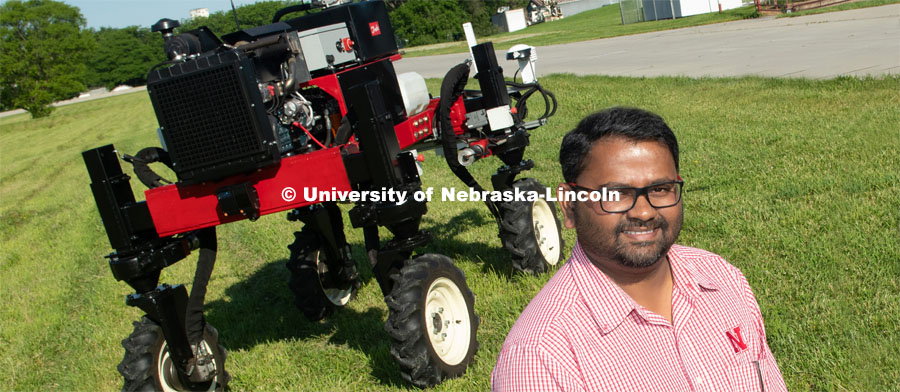 Grad student Josh Murman is with Santosh Pitla, associate professor of advanced machinery systems in the Department of Biological Systems Engineering at the University of Nebraska–Lincoln. Pitla is currently developing an autonomous tractor using ground robotics. Pitla and his team are testing their driverless tractor on the tractor testing field on East Campus. The autonomous tractors are named Flexible Structured Robotic Vehicle (FlexRo), the tractor is currently used for plant phenotyping, which is measuring the physical characteristics of the plant. According to Pitla, cameras are added to the machine to collect images that characterize plant conditions. Photo for the 2019 publication of the Strategic Discussions for Nebraska magazine. June 10, 2019, Photo by Gregory Nathan / University Communication. 