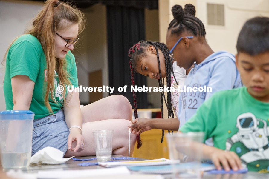 Elizabeth Brison, a UNO sophomore working with Extension this summer, watches as students place droplets of water on fabric samples. Elementary-age students in Omaha's Kennedy Elementary learned about nano technology and water Wednesday afternoon. STEMentors is helping put on summer camps with Imagine Science. June 19, 2019. Photo by Craig Chandler / University Communication.