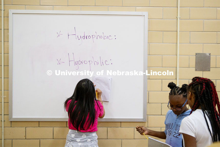Students write down the science terms they are learning about so they can write their reports. Elementary-age students in Omaha's Kennedy Elementary learned about nano technology and water Wednesday afternoon. STEMentors is helping put on summer camps with Imagine Science. June 19, 2019. Photo by Craig Chandler / University Communication.