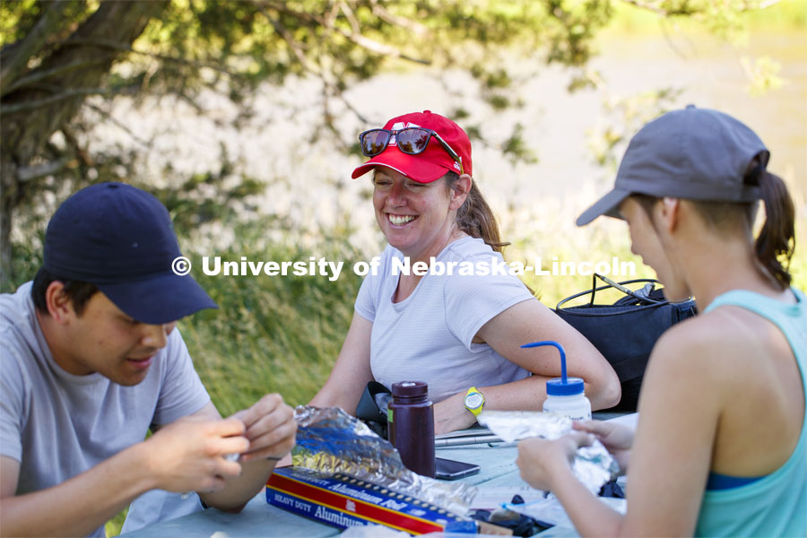 Jessica Corman talks with Matthew Chen as he helps Kayla Vondracek work on the cobble samples. Jessica Corman, assistant professor in the School of Natural Resources, UCARE research group researching algae in the Niobrara River. Fort Niobrara National Wildlife Refuge. July 12, 2019. Photo by Craig Chandler / University Communication.