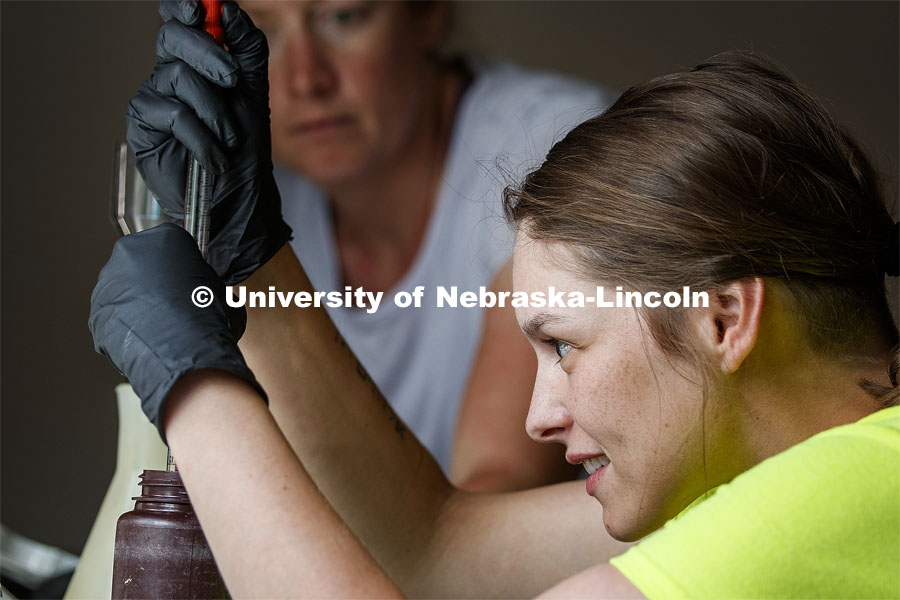 Kayla Vondracek processes an algae-filled water sample at the Niobrara Valley Preserve as Professor Jessica Corman supervises. Jessica Corman, assistant professor in the School of Natural Resources, UCARE research group researching algae in the Niobrara River. Fort Niobrara National Wildlife Refuge. July 12, 2019. Photo by Craig Chandler / University Communication.
