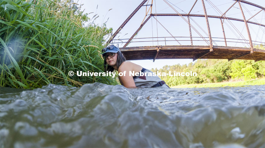 Sydney Kimnach, sophomore in environmental studies and fisheries and wildlife management, fixes her research project to the bank of the Niobrara. She places a collection of filter plates each saturated with elements, such as potassium, to see if the algae are attracted to various nutrients.  Her multiple sites also allow her to research if algae in different areas of the river seek out different nutrients. Jessica Corman, assistant professor in the School of Natural Resources, UCARE research group researching algae in the Niobrara River. Fort Niobrara National Wildlife Refuge. July 12, 2019. Photo by Craig Chandler / University Communication.