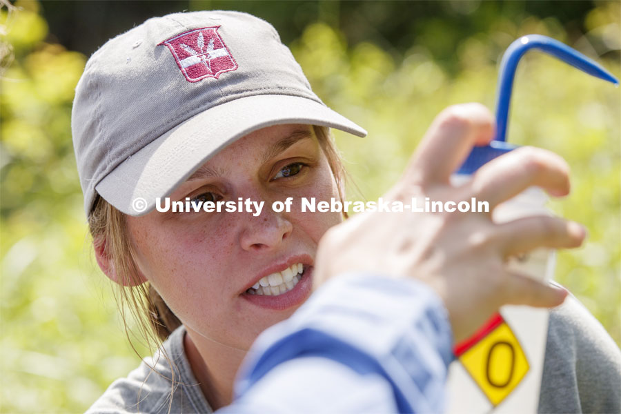 Kayla Vondracek gauges the amount of filtered water left to complete her sampling. Jessica Corman, assistant professor in the School of Natural Resources, UCARE research group researching algae in the Niobrara River. Fort Niobrara National Wildlife Refuge. July 13, 2019. Photo by Craig Chandler / University Communication.