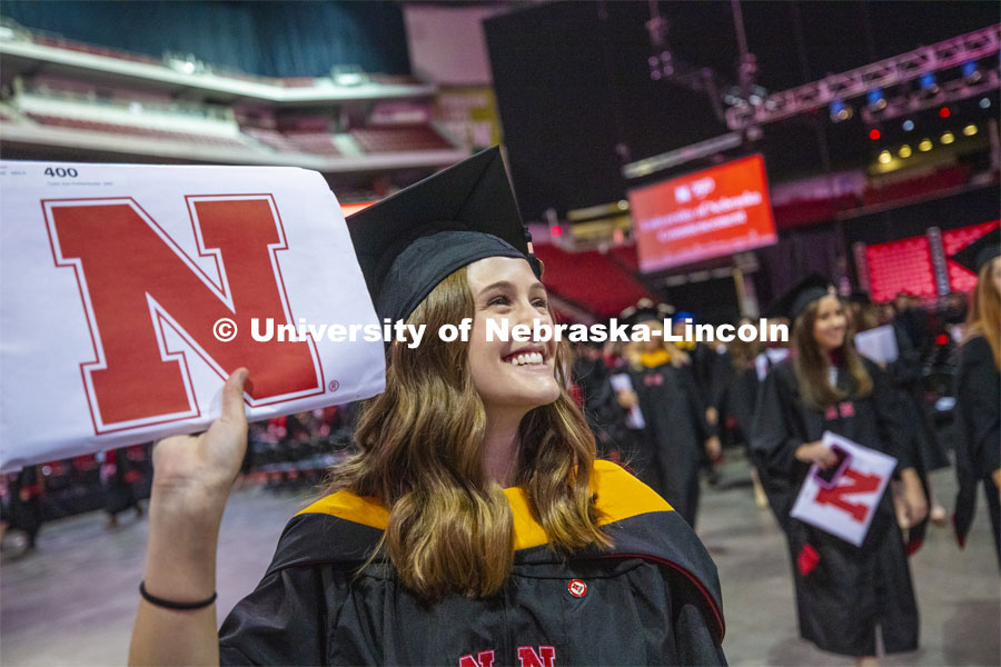 Taylor Knickerbocker shows off her diploma to family and friends as she leaves the arena following commencement. 2019 Summer Commencement at Pinnacle Bank Arena. August 17, 2019. Photo by Craig Chandler / University Communication.