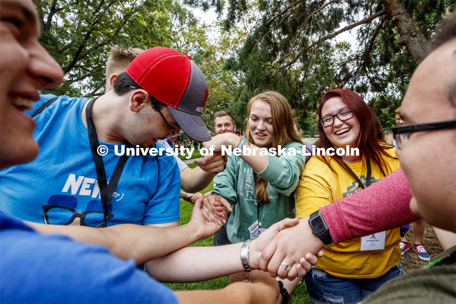 Kyle Harris of Elkhorn, NE, Brandy Kinnander of Armsrong, IA, and Anastasia Paitz of Waverly, NE, try to untangle themselves from a human knot as part of an ice-breaker at the First Husker Welcome. August 18, 2019. Photo by Craig Chandler / University Communication.