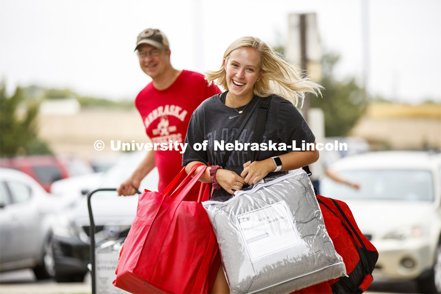 Stephanie Rottmann of Castle Rock, Colorado, carries an arm-load of belongings into Schramm Hall Residence Hall Sunday morning. Residence Hall Move-in. August 18, 2019. Photo by Craig Chandler / University Communication.