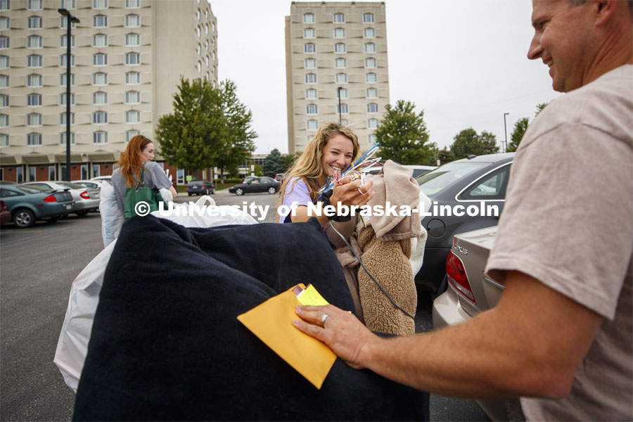Holly Romick laughs after snagging her keys from falling off her cart stacked full of belongings.  Holly with her parents, Josh and Kortney, are from Des Moines, Iowa. Residence Hall Move-in. August 18, 2019. Photo by Craig Chandler / University Communication.