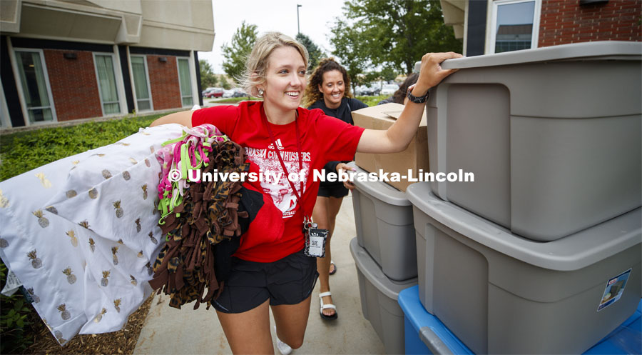 Kealey Franzen from Kearney steadies the load of totes as she moves into her Schramm Hall room. Residence Hall Move-in. August 18, 2019. Photo by Craig Chandler / University Communication.