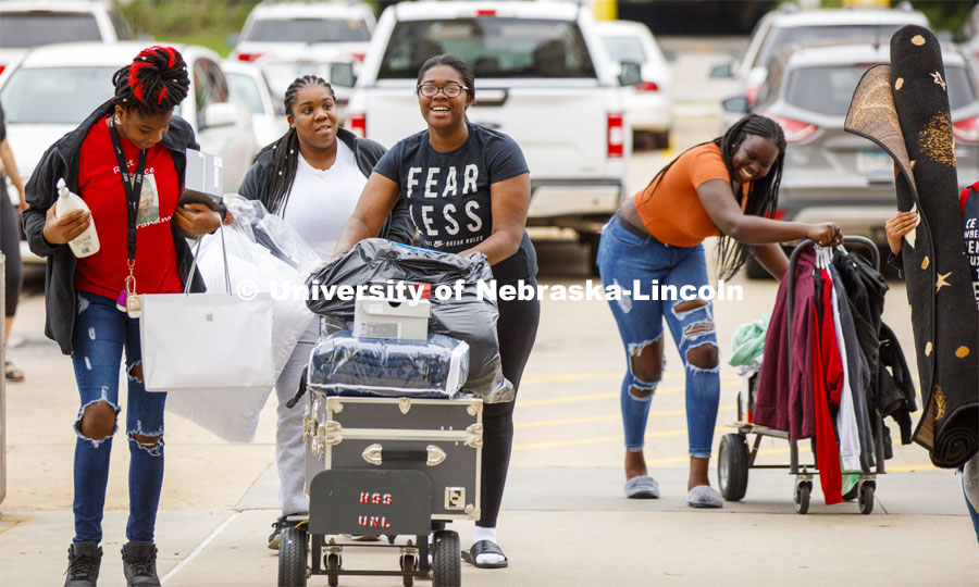 Ma-Kiya Carter family and friends help her wheel here belongings to her Harper Hall room. She is a first-generation student. Residence Hall Move-in. August 18, 2019. Photo by Craig Chandler / University Communication.