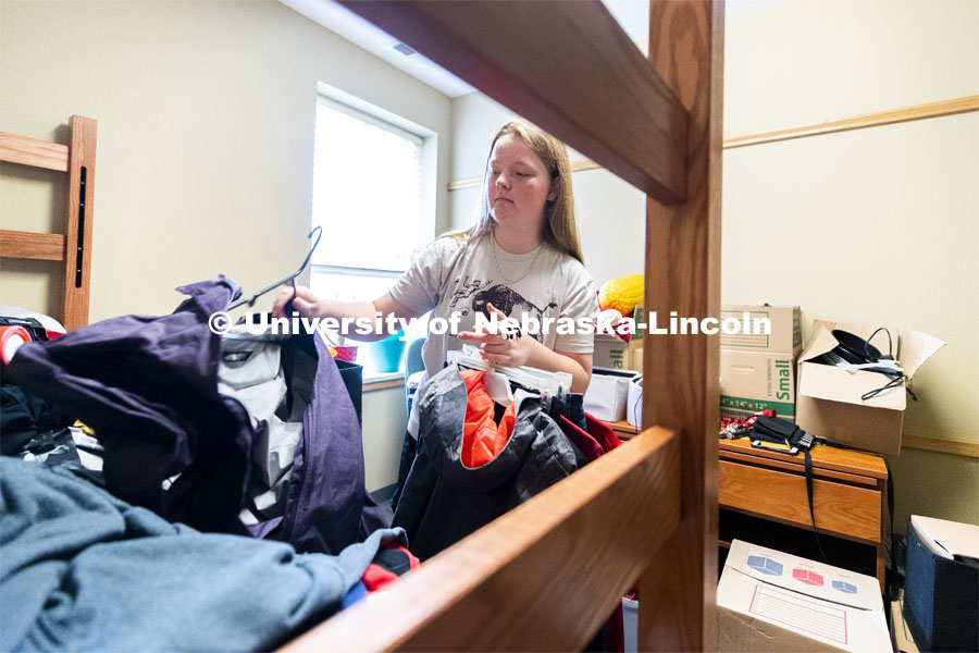 Abi Schoup hangs up clothes in her room. Abi is a freshman in the Honors program. She is originally from Casper, Wyoming, but her parents are also moving this week to McCook, Nebraska. Residential hall move-in to the Knoll Residential Center and University Suites. August 22, 2019. Photo by Craig Chandler / University Communication.