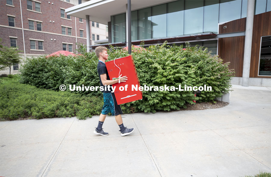 Jeremy Schepler of Wilcox, Nebraska, carries a refrigerator into Knoll Residence Hall. Jeremy is a freshman in the Honors program. Residential hall move-in to the Knoll Residential Center and University Suites. August 22, 2019. Photo by Craig Chandler / University Communication.