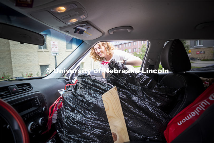 Gabie Lockard, a freshman from Grand Island, unloads the front seat of her car Thursday morning. Residential hall move-in to the Knoll Residential Center and University Suites. August 22, 2019. Photo by Craig Chandler / University Communication.