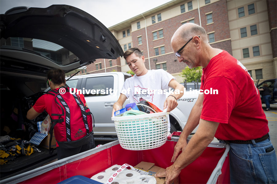 Stephen Hintz of Milwaukee, Wisconsin, loads a cart with the help of his parents, Dave and Rachel. Stephen is a freshman in the Honors program. Residential hall move-in to the Knoll Residential Center and University Suites. August 22, 2019. Photo by Craig Chandler / University Communication.