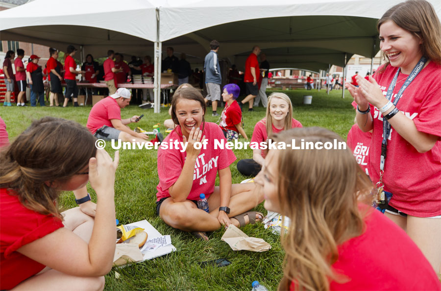 Addison Wittrock of Overland Park, center, and Aubrey Koenig, also of Overland Park, at right, laugh at the story told by their Resident Assistant Rhiannon Cobb. The group lives on Schramm 8. Big Red Welcome, Chancellor's BBQ for incoming freshman and new students on the greenspace by the Memorial Union. August 23, 2019. Photo by Craig Chandler / University Communication.