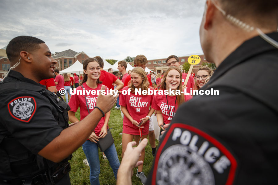 UNL Police Officers Terrell Long Jr. and Craig Tepley engage with students in an in-depth conversation on why the game is called corn hole in Nebraska. Big Red Welcome, Chancellor's BBQ for incoming freshman and new students on the greenspace by the Memorial Union. August 23, 2019. Photo by Craig Chandler / University Communication.