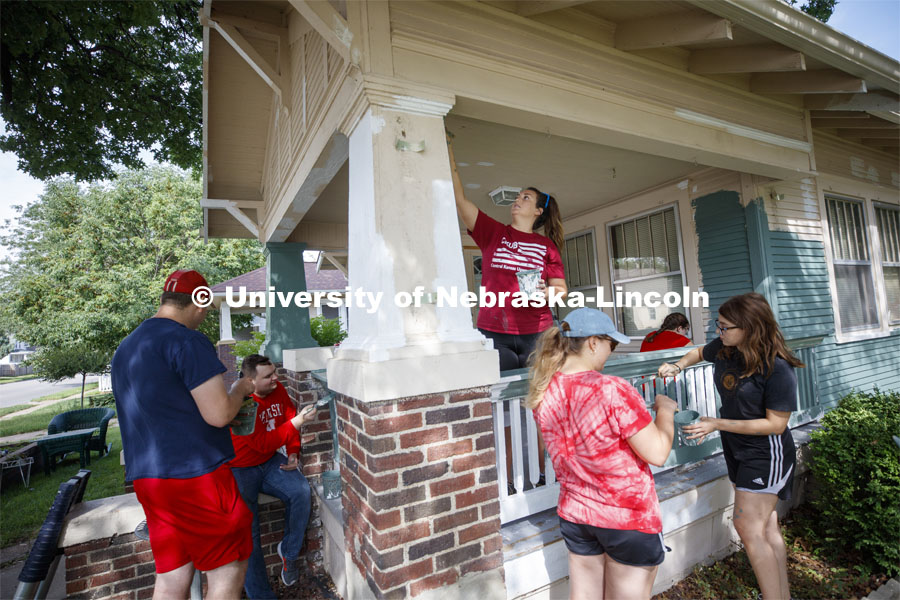 Mackenzie Orchard of Wichita, KS, paints a porch column as first year law students, faculty and staff paint one of two Lincoln houses Saturday morning.  The painting is a yearly tradition for the incoming students. August 24, 2019. Photo by Craig Chandler / University Communication.