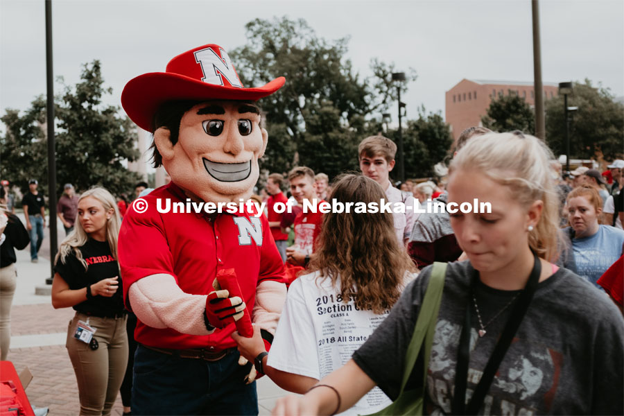 Herbie handing out free stuff. Students had the opportunity to engage with more than 350 booths hosted by local business, student organizations and clubs, UNL departments and more at the Big Red Welcome Street Festival. There were free food, prizes, and giveaways. August 24, 2019. Photo by Justin Mohling / University Communication.