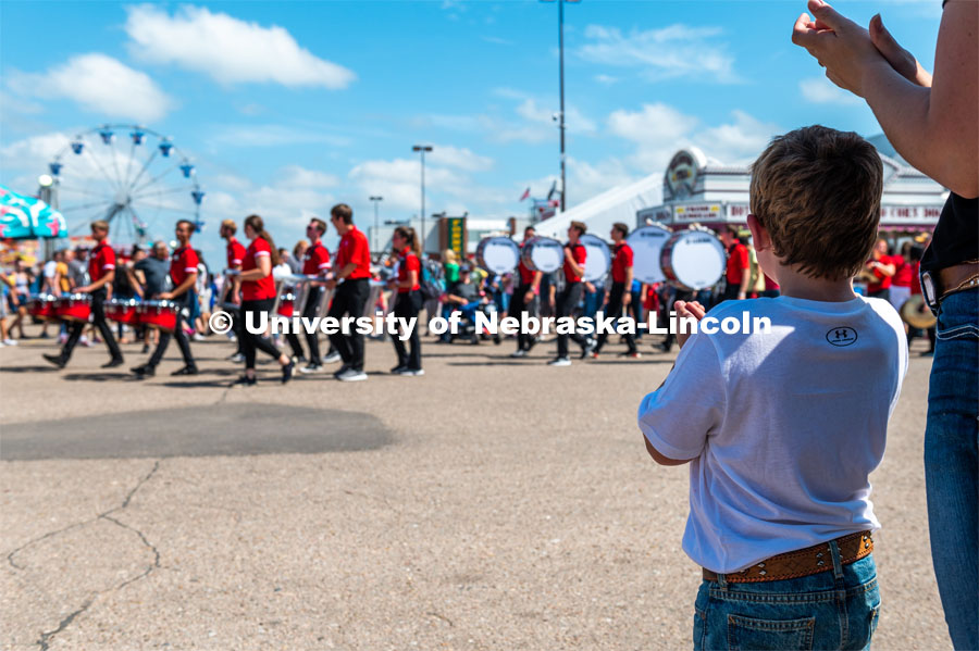 Kids watch the Cornhusker Marching Band march by. The University of Nebraska represents and celebrates their 150th year anniversary at the Nebraska State Fair in Grand Island, Nebraska. August 1, 2019. Photo by Justin Mohling for University Communication.