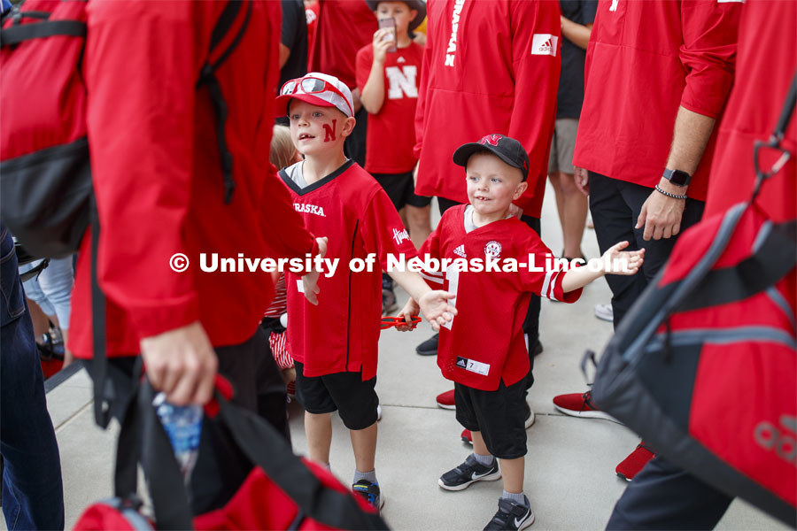 Footbal players high-five young fans as the do the Unity Walk. Nebraska vs. Northern Illinois football game. September 14, 2019. Photo by Craig Chandler / University Communication.