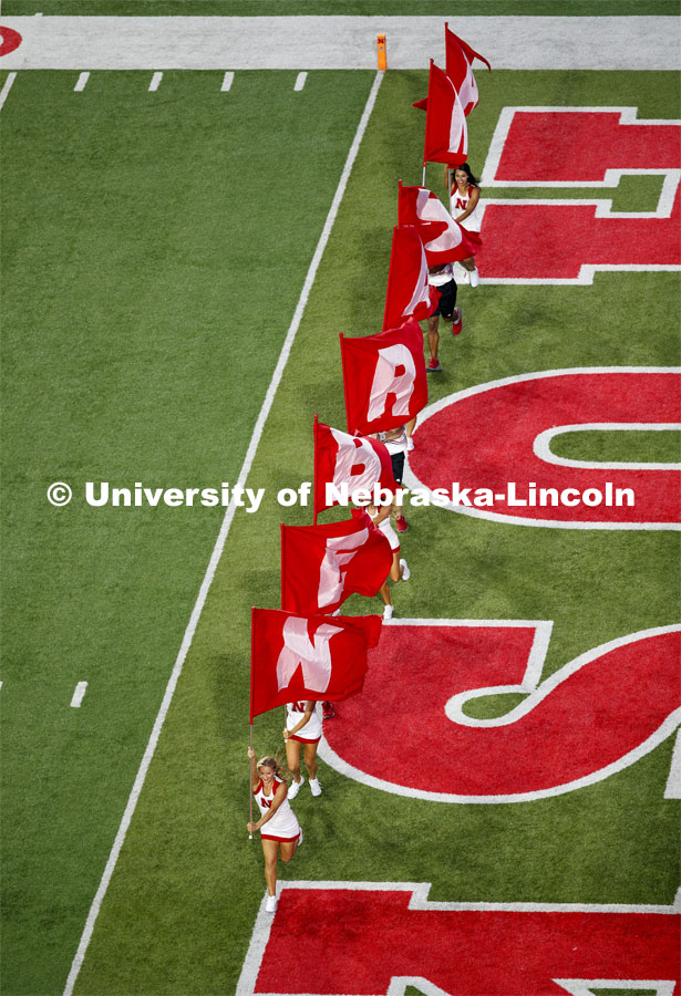 The Husker Spirit Squad spell out NEBRASKA with flags as they run out onto the field at the Nebraska vs. Northern Illinois football game. September 14, 2019. Photo by Craig Chandler / University Communication.