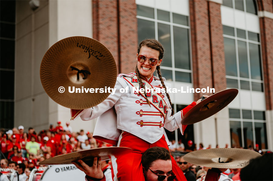 Cornhusker Marching Band, Lauren McNeal Playing cymbals on shoulders of Luke Bogus. Nebraska vs. Northern Illinois football game. September 14, 2019. Photo by Justin Mohling / University Communication.