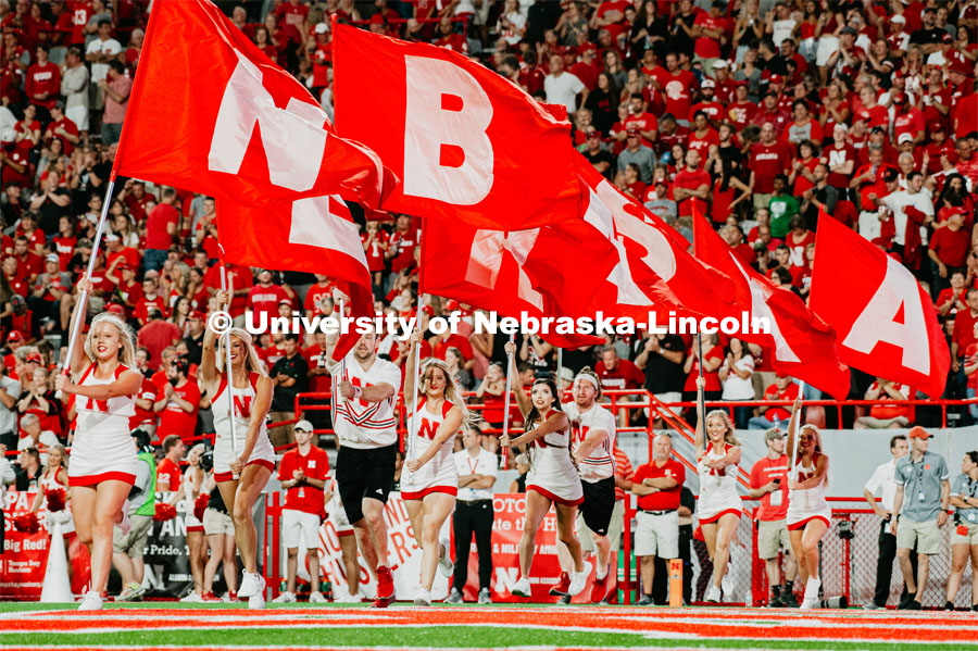 Cheerleaders spelling out NEBRASKA with flags as they run across the field. Nebraska vs. Northern Illinois football game. September 14, 2019. Photo by Justin Mohling / University Communication.