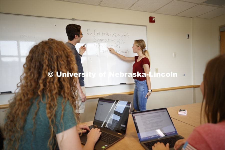 Students studying in a classroom, working through a problem on the marker board. Raikes school photo shoot. September 25, 2019. Photo by Craig Chandler / University Communication.