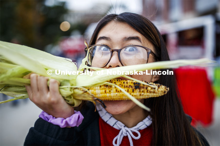 Christine Trinh, freshman from Lincoln, tries an ear of grilled corn. Cornstock celebration and Homecoming Parade. October 4, 2019. Photo by Craig Chandler / University Communication.