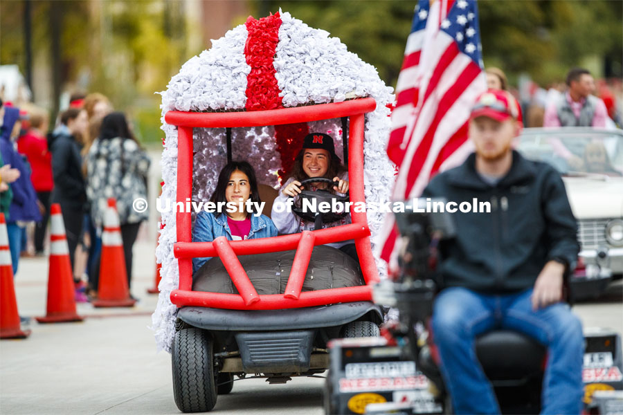Triad 4's golf cart rolls along the parade route. Triad 4's members are Phi Kappa Psi, Delta Gamma, Pi Kappa Alpha, Tau Kappa Alpha, Tau Kappa Epsilon, Sigma Alllpha, Beta Sigma Psi, Sigma Nu. Cornstock celebration and Homecoming Parade. October 4, 2019. Photo by Craig Chandler / University Communication.