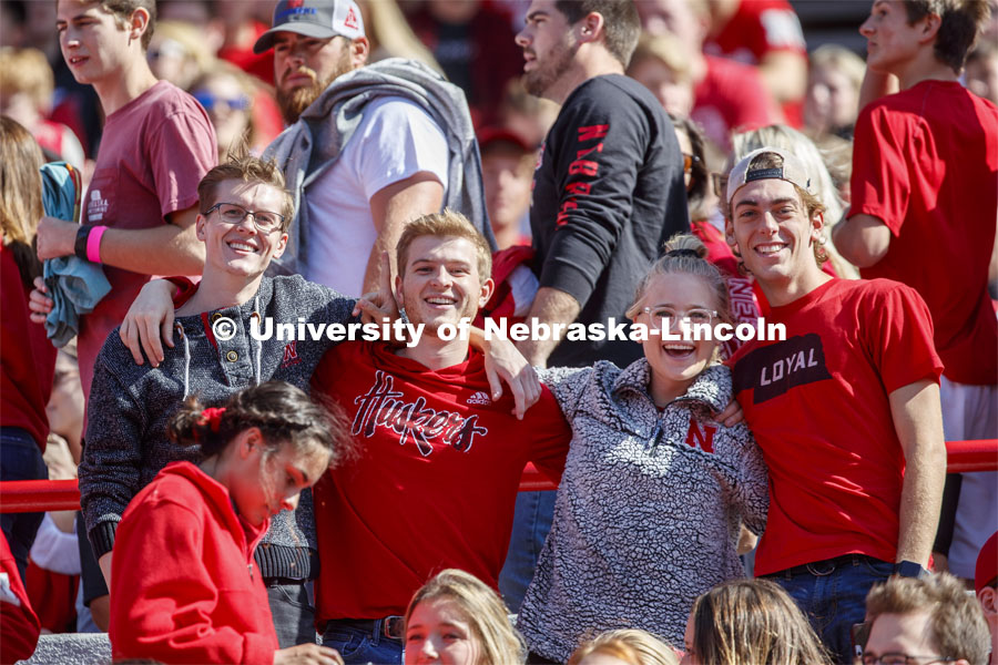 Fans in the student section link arms together and pose for a picture. Nebraska vs. Northwestern University football game. Homecoming 2019. October 5, 2019.  Photo by Craig Chandler / University Communication.