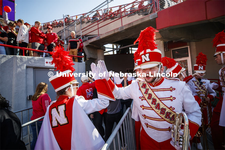 Band members high-five as they pass one another. Nebraska vs. Northwestern University football game. Homecoming 2019. October 5, 2019.  Photo by Craig Chandler / University Communication.