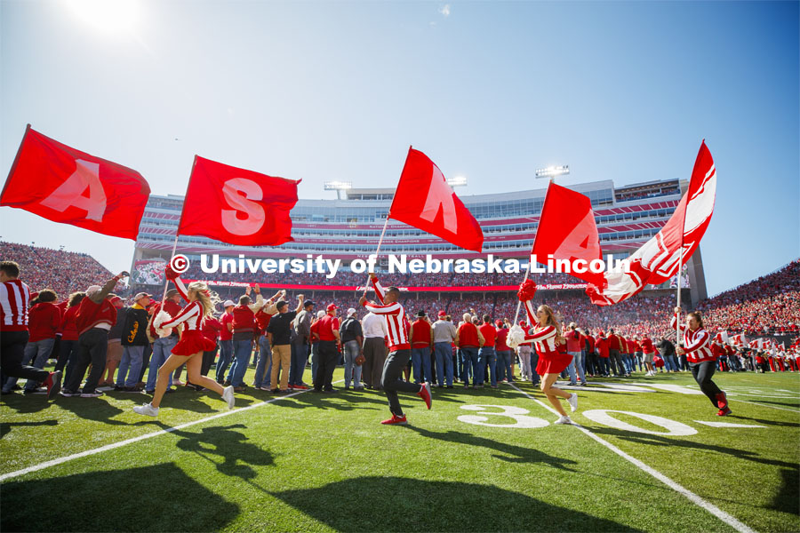 The Cheer Squad run across the field carrying flags that spell NEBRASKA. Nebraska vs. Northwestern University football game. Homecoming 2019. October 5, 2019.  Photo by Craig Chandler / University Communication.