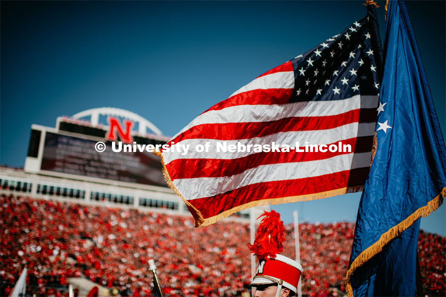 The United States and Nebraska Flags billow in the breeze with the Jumbo Tron in the background. Nebraska vs. Indiana University football game. October 26, 2019. Photo by Justin Mohling / University Communication.