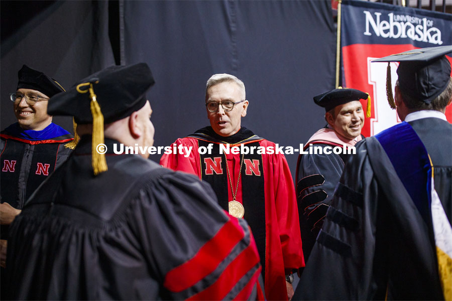 Chancellor Ronnie Green center, Commencement speaker L.J. McElravy, left, and Faculty Senate President Kevin Hanrahan, greet doctoral degree candidates and their advisors the Graduate Commencement and Hooding in Pinnacle Bank Arena. 2019 Graduate Commencement. December 20, 2019. Photo by Craig Chandler / University Communication.