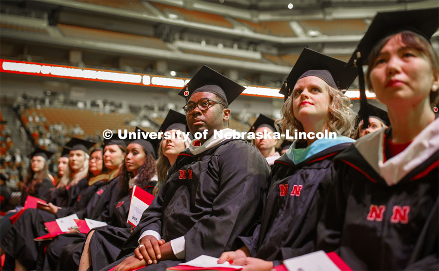 Christopher Askew watches the greetings on the video screen at the start of the Graduate Commencement and Hooding at the Pinnacle Bank Arena. December 20, 2019. Photo by Craig Chandler / University Communication.