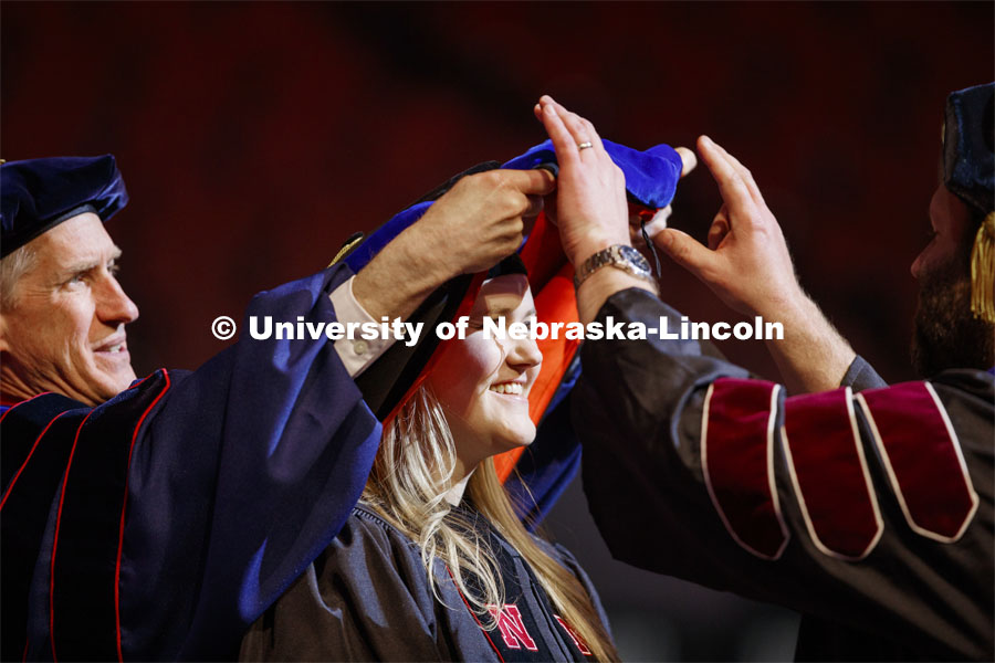 Caitlin Cadaret has her hood placed over her head. She received a doctor of philosophy in animal science. Graduate Commencement and Hooding at the Pinnacle Bank Arena. December 20, 2019. Photo by Craig Chandler / University Communication.
