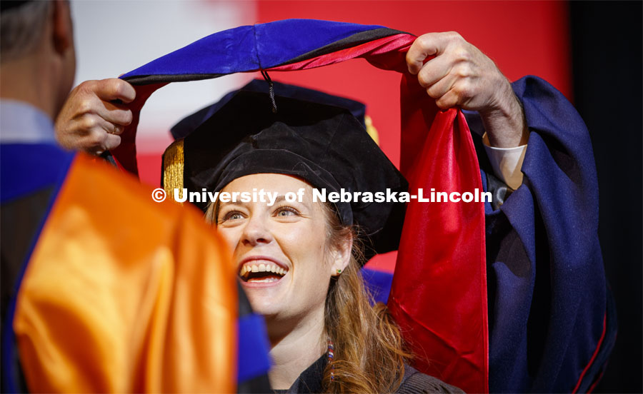 Christina Hein smiles at her advisor, Professor David DiLillo, as she is hooded. Graduate Commencement and Hooding at the Pinnacle Bank Arena. December 20, 2019. Photo by Craig Chandler / University Communication.