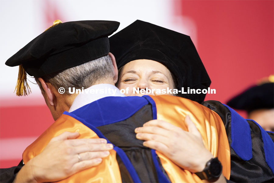 Christina Hein hugs her advisor, Professor David DiLillo, after she received her doctoral hood. Graduate Commencement and Hooding at the Pinnacle Bank Arena. December 20, 2019. Photo by Craig Chandler / University Communication.