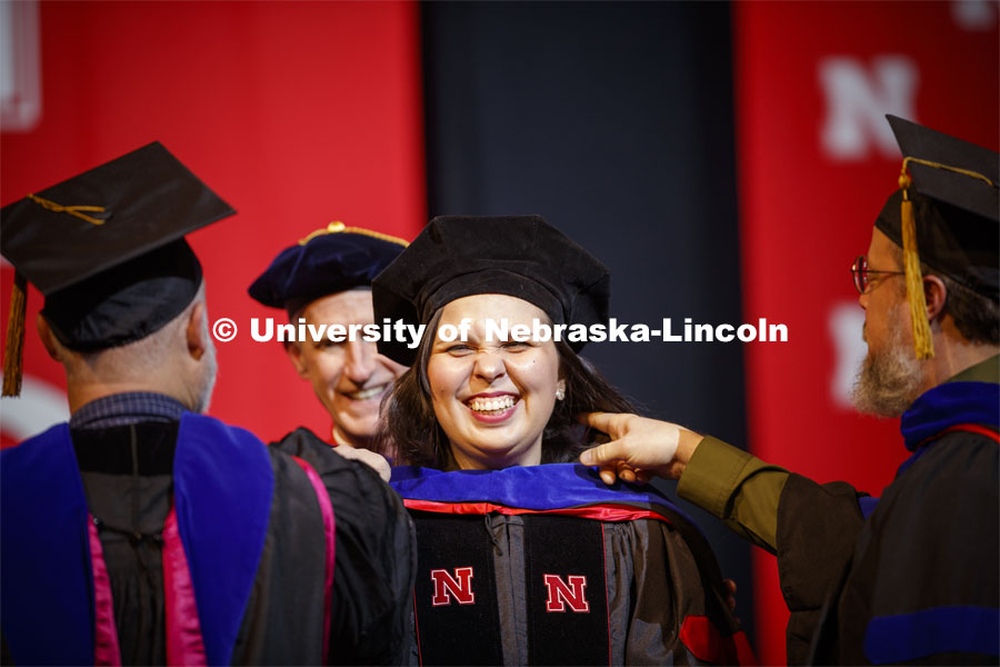 Raquel de Oliveira Rocha smiles as she is hooded at the Graduate Commencement and Hooding at the Pinnacle Bank Arena. December 20, 2019. Photo by Craig Chandler / University Communication.
