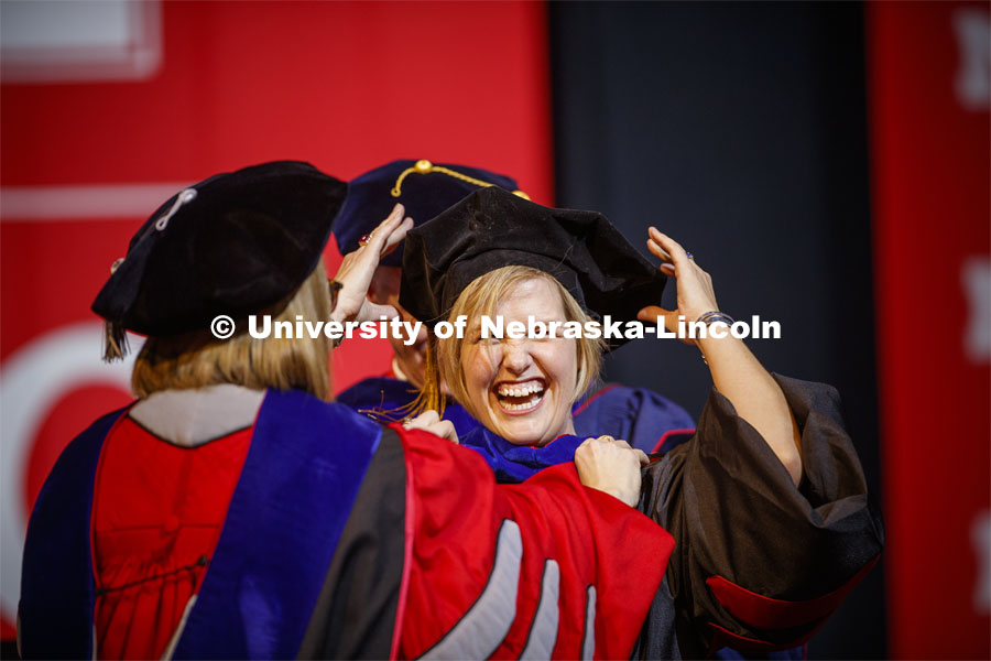 Heather Vorrhees laughs as her cap is knocked askew while being hooded at the Graduate Commencement and Hooding at the Pinnacle Bank Arena. December 20, 2019. Photo by Craig Chandler / University Communication.