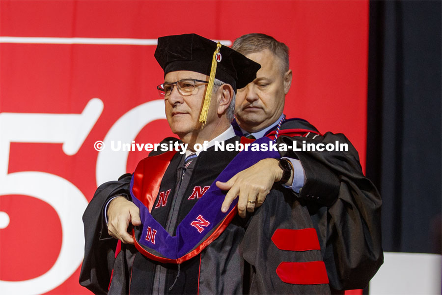 University of Nebraska Regent Robert Schafer places the hood on Mike Johanns.  Johanns was conferred an honorary doctor of laws degree. December Undergraduate commencement at Pinnacle Bank Arena. December 21, 2019. Photo by Craig Chandler / University Communication.
