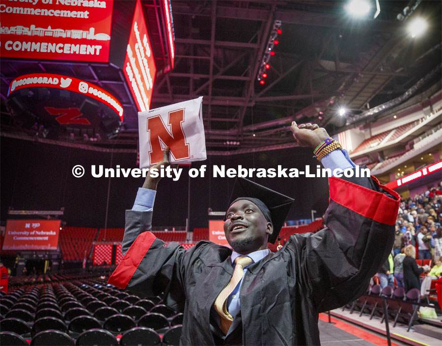 Septer Duang celebrates his degree with family and friends as he leaves the arena. December Undergraduate commencement at Pinnacle Bank Arena. December 21, 2019. Photo by Craig Chandler / University Communication.