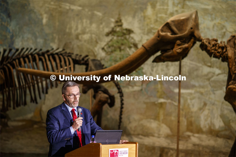 Chancellor Ronnie Green introduces Ross Secord and his Nebraska Lecture as a Stegomastodon skeleton stands in the background. Ross Secord's lecture, Looking Back and Looking Forward: The History of Vertebrate Paleontology at the University of Nebraska State Museum, was given at the Nebraska State Museum. January 28, 2020. Photo by Craig Chandler / University Communication.