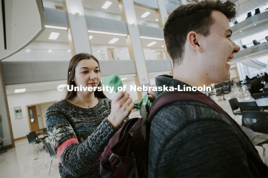 Erika Swenson a junior in wildlife and fisheries management with ASUN ties a green bandana on Justin Myers backpack. The bandanas are being given out to promote mental health awareness on campus. January 29, 2020. Photo by Craig Chandler / University Communication.