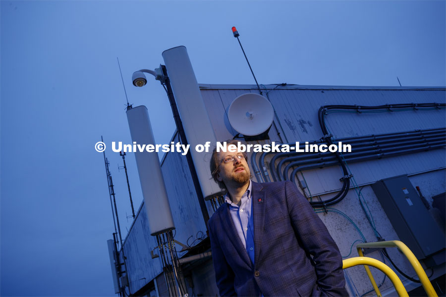 Gus Hurwitz, Nebraska Law professor researching rural broadband issues in Nebraska. He is standing amongst the telecommunications equipment that covers the roof of Oldfather Hall. January 31, 2020. Photo by Craig Chandler / University Communication.