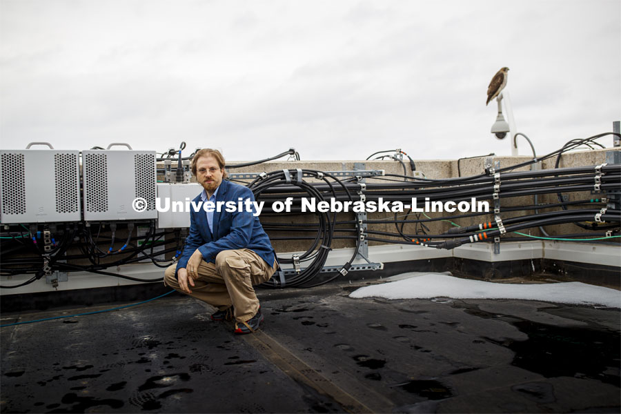 Gus Hurwitz, Nebraska Law professor researching rural broadband issues in Nebraska. He is amongst the telecommunications equipment that covers the roof of Oldfather Hall. January 31, 2020. Photo by Craig Chandler / University Communication.