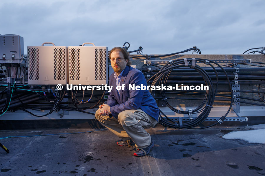 Gus Hurwitz, Nebraska Law professor researching rural broadband issues in Nebraska. He is amongst the telecommunications equipment that covers the roof of Oldfather Hall. January 31, 2020. Photo by Craig Chandler / University Communication.