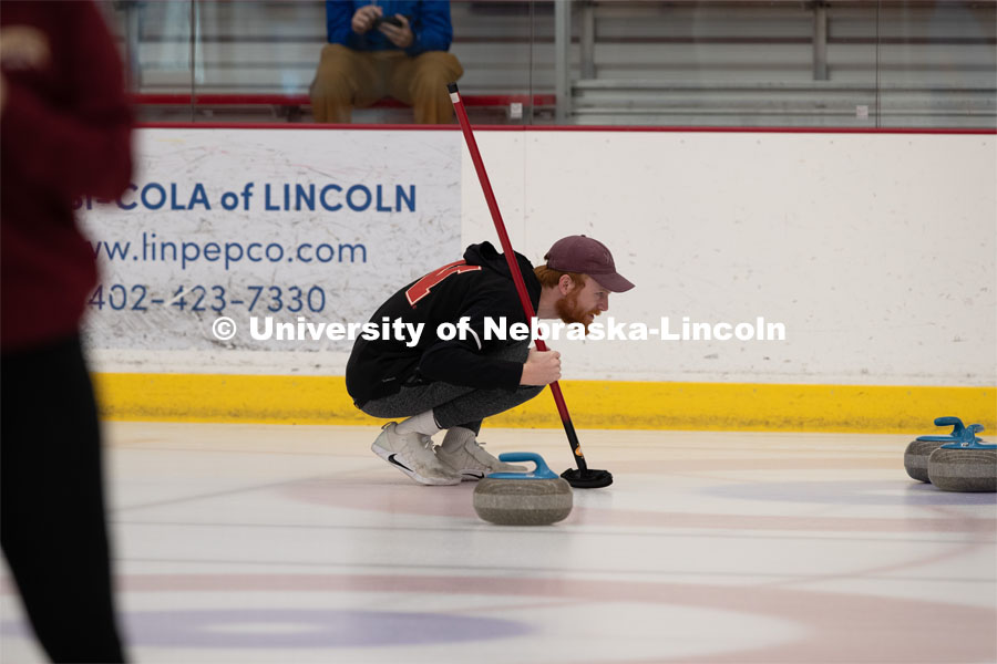 Colin Wooldrik of the UNL Curling Team is looking over the stones in the house (the scoring area) to see what the team’s next throw will be. Nebraska's nationally-ranked curling club host its first bonspiel at the John Breslow Ice Hockey Center this weekend. The bonspiel — or tournament — featured seven traveling schools from across the Midwest. February 1, 2020. Photo by Gregory Nathan / University Communication.